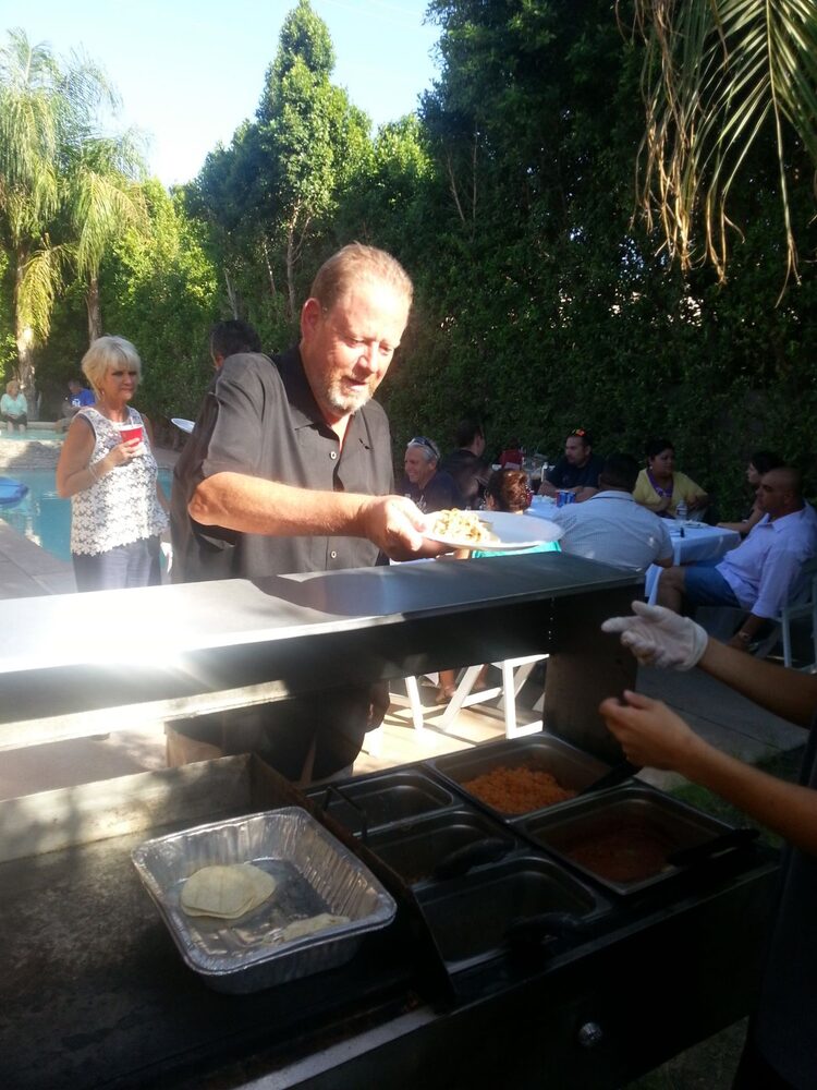 Tacos cooking on the grill at a catering event