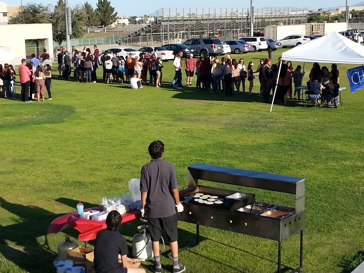 Guests gathered on a lawn at a taco catering event