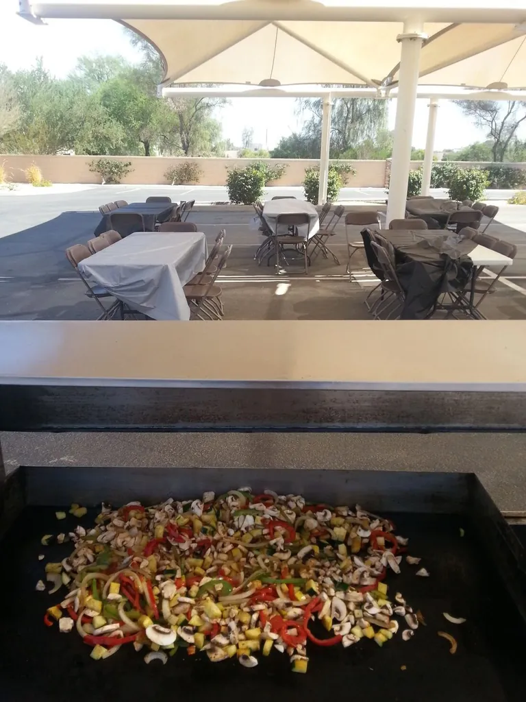 Tacos and meat cooking on a flat-top grill